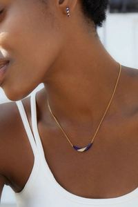 Detail of 925 silver 18K gold plated necklace with blue enamel crescent pendant