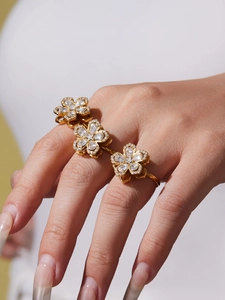 Dettaglio macro dell'anello a tre dita placcato oro 18K con fiori incastonati di zirconi