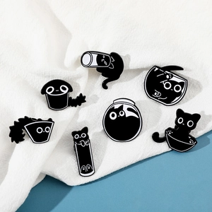 Set of 7 cartoon black cat enamel pins showing cats in various containers on white fabric