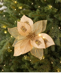 Close-up of golden Christmas poinsettia decoration with glitter petals on a festive tree