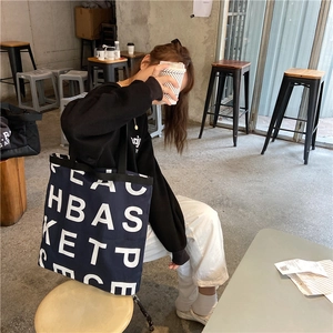 Detail of navy blue large canvas tote bag with white lettering for office commute