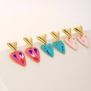 Detailed view of colorful heart-shaped enamel earrings with golden plated metal texture