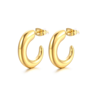 Polished thick golden C-shaped hoop earrings in stainless steel on a white background