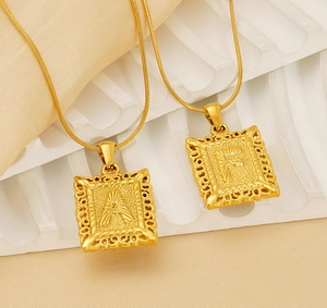 Macro shot of gold square alphabet pendants with intricate filigree and A-F relief