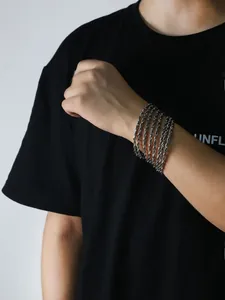 Close-up of a silver multi-layer rope chain bracelet with a heavy metallic texture on wrist