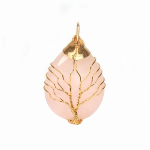 Close-up of handmade rose quartz tree of life pendant with golden wire wrap design
