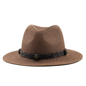 Close-up of a dark brown straw fedora featuring a leather band with metal rivets