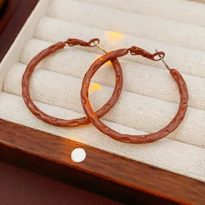 Terracotta brown hammer textured hoop earrings in a minimalist retro vintage style