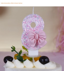Close-up of pink glitter number 8 birthday candle with bow on a blueberry cream cake