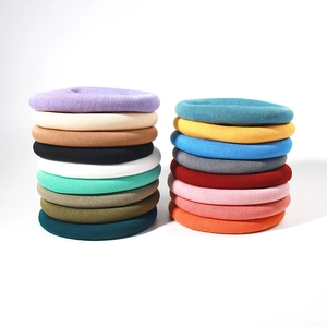 Detailed display of knitted beret hats available in over 18 diverse solid colors