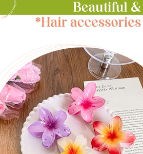 Detail view of colorful resin flower hair claws in a decorative white porcelain dish
