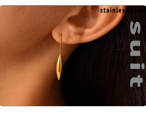 Macro view of 18K gold plated stainless steel teardrop earrings worn on an ear