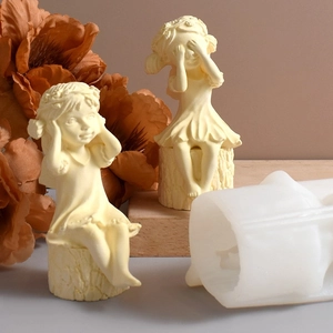 Macro detail of silicone molds and finished girl statues sitting on tree stumps