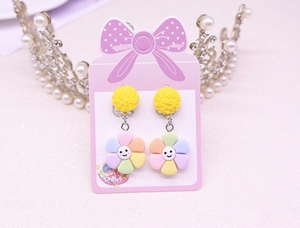 Close-up of kids rainbow flower clip-on earrings with smiley face on card display