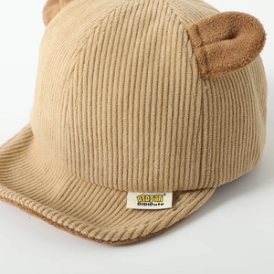 Detail of baby corduroy baseball cap in brown featuring cute bear ears and soft brim