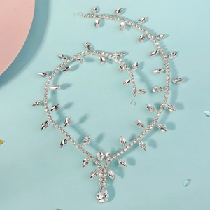 Close-up of silver bridal headpiece featuring leaf and teardrop rhinestone designs