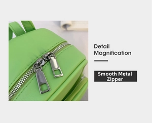 Detail of the bright green leather backpack featuring smooth dual silver metal zippers