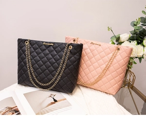 Gros plan de sacs cabas matelassés noir et rose avec chaînes dorées et logo métal