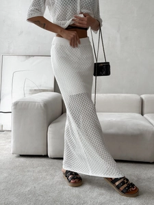 Close-up of white crochet knit set featuring detailed hollow-out texture and buttons