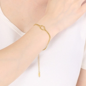Close-up of gold knotted snake chain bracelet with adjustable extender on female wrist