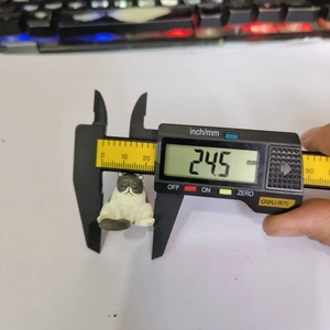 Detailed measurement of the 24.5mm mini resin cat figurine using digital calipers