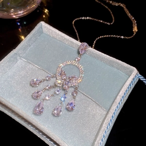 Détail du collier argenté avec pendentif en zircone et glands en forme de goutte d'eau