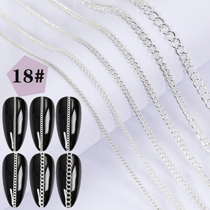 Detail of six silver metal nail art chains in various sizes with rhinestone accents