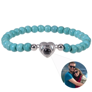 Detail of turquoise bead bracelet showing heart projection charm with custom photo inside