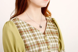 Silver heart pendant necklace shown on model with polished titanium steel finish