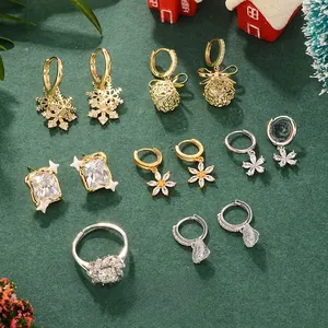 Close-up of festive floral earrings and zircon jewelry set on a deep green surface