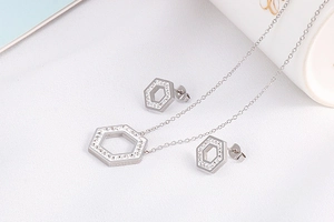 Detailed view of silver hexagonal jewelry set featuring rhinestone studded pendant and studs