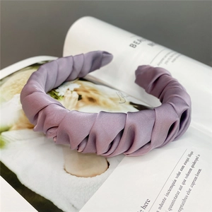 Detail showing the pleated satin texture and twisted design of this purple headband