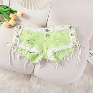 Detalle de shorts vaqueros verde neón con cordones laterales y dobladillo deshilachado