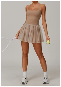 Full view of khaki mock two-piece mesh tennis dress for women in a studio setting