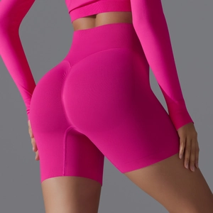 Detail of high-waisted hot pink seamless yoga shorts with ribbed texture and scrunch butt