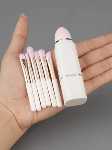 Detail of a portable 8-in-1 mini makeup brush set with pink bristles and storage case