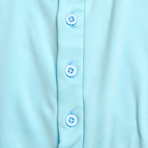 Détail du tissu bleu clair de la robe avec patte de boutonnage et boutons assortis