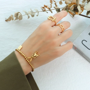 Goldenes Perlenarmband-Set mit Hasenanhänger und Ringen auf weißem Hintergrund
