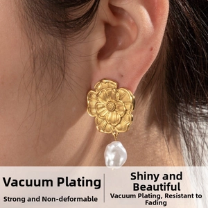 Detail of vintage gold flower earrings with baroque pearl drop on model's ear
