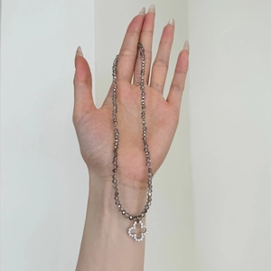 Detailed view of S925 silver necklace with faceted beads and clover pendant on hand