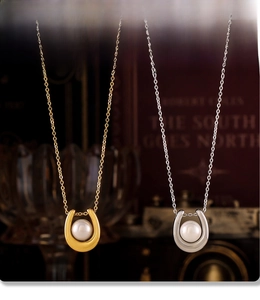Macro detail of PVD electroplated horseshoe pendants with pearls in gold and silver