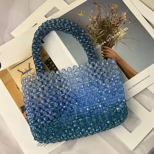 Detail of handmade beaded tote bag showing gradient blue acrylic beads and woven texture