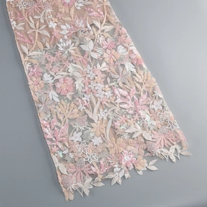 Detailed view of floral embroidery with sequins on breathable mesh fabric of the gown