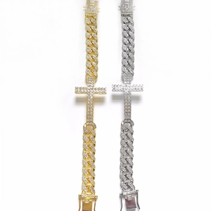 Detailed close-up of gold and silver iced-out Cuban chain bracelets with diamond crosses