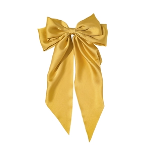 Elegant large gold satin bow hair clip with long ribbons and smooth glossy finish