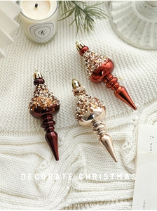 Three elegant spindle Christmas ornaments with sequins on cozy white knitted background