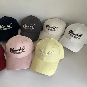 Détail de diverses casquettes de baseball colorées avec broderie de lettres élégantes
