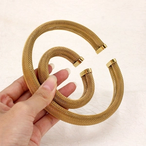 Detail of 18K gold plated mesh cuff bracelets showing the intricate weave and smooth ends