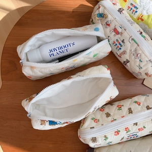 Quilted cotton pencil case with cute bear and floral prints on a wooden surface