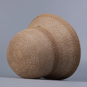 Close-up of brown woven sun hat featuring detailed texture and a metal accent